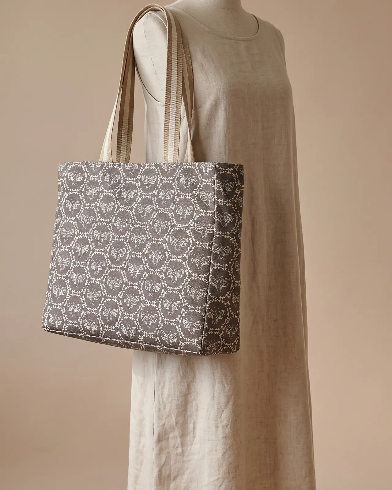Large Tote Bag - Taupe Moth worn on the shoulder on a display form